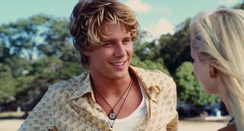 Movie still from “Aquamarine” (2006), directed by Elizabeth Allen Rosenbaum – A young man with blonde hair wearing a necklace; Close Up shot, Over the shoulder angle