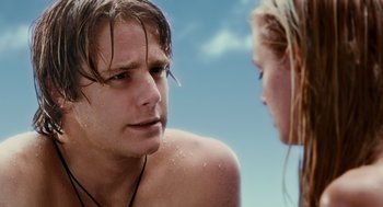 Movie still from “Aquamarine” (2006), directed by Elizabeth Allen Rosenbaum – A man and a woman standing next to each other on the beach; Close Up shot, Over the shoulder angle