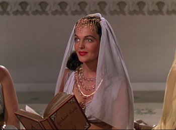 Movie still from “Arabian Nights” (1942), directed by John Rawlins – A beautiful woman wearing a veil holding an open book; Medium shot, Low angle
