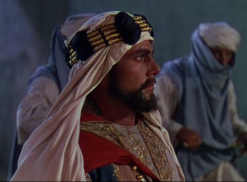 Movie still from “Arabian Nights” (1942), directed by John Rawlins – A man with a beard wearing a turban; Medium shot, Over the shoulder angle