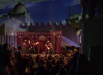 Movie still from “Arabian Nights” (1942), directed by John Rawlins – A crowd of people sitting around a stage; Extreme Wide shot, Low angle