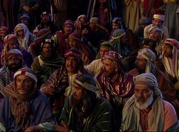 Movie still from “Arabian Nights” (1942), directed by John Rawlins – A group of men sitting next to each other; Wide shot, High angle