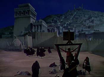Movie still from “Arabian Nights” (1942), directed by John Rawlins – A group of people standing in a field with buildings in the background; Extreme Wide shot, High angle