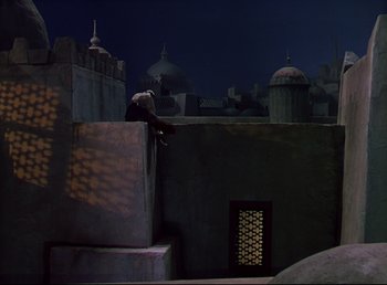 Movie still from “Arabian Nights” (1942), directed by John Rawlins – A bird sitting on top of a building at night; Extreme Wide shot, Low angle