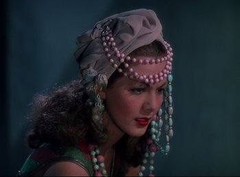 Movie still from “Arabian Nights” (1942), directed by John Rawlins – A woman wearing a head scarf and jewelry; Close Up shot, Over the shoulder angle