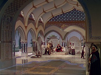 Movie still from “Arabian Nights” (1942), directed by John Rawlins – A group of people standing around a room; Extreme Wide shot, High angle