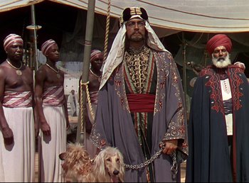 Movie still from “Arabian Nights” (1942), directed by John Rawlins – A group of men standing next to each other with animals; Wide shot, Low angle
