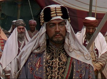 Movie still from “Arabian Nights” (1942), directed by John Rawlins – A group of men in traditional clothing standing next to each other; Close Up shot, Over the shoulder angle