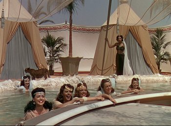 Movie still from “Arabian Nights” (1942), directed by John Rawlins – A group of women sitting in a pool of water; Wide shot, High angle