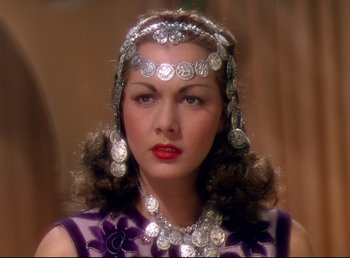 Movie still from “Arabian Nights” (1942), directed by John Rawlins – A woman wearing a necklace and a head piece; Close Up shot, High angle
