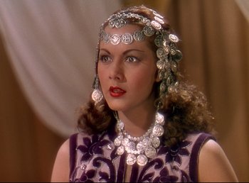Movie still from “Arabian Nights” (1942), directed by John Rawlins – A woman wearing a necklace and a head piece; Close Up shot, Over the shoulder angle