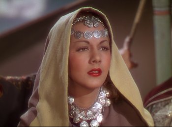 Movie still from “Arabian Nights” (1942), directed by John Rawlins – A woman wearing a headdress and a necklace; Close Up shot, Over the shoulder angle