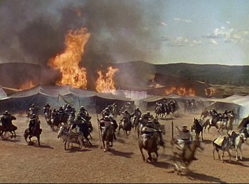 Movie still from “Arabian Nights” (1942), directed by John Rawlins – A group of people riding horses through a field; Extreme Wide shot, High angle