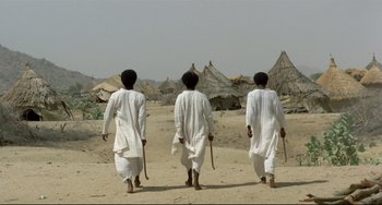 Movie still from “Arabian Nights” (1974), directed by Pier Paolo Pasolini – A group of men walking across a dirt field; Wide shot, Low angle