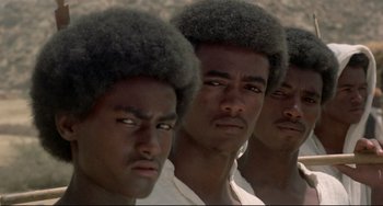 Movie still from “Arabian Nights” (1974), directed by Pier Paolo Pasolini – A group of men with very long black hair; Close Up shot, High angle