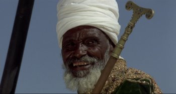 Movie still from “Arabian Nights” (1974), directed by Pier Paolo Pasolini – An old man with a white turban and a white beard; Close Up shot, Low angle
