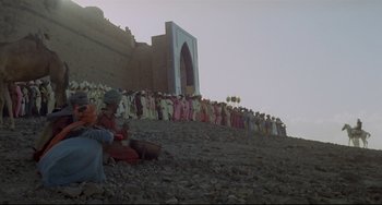 Movie still from “Arabian Nights” (1974), directed by Pier Paolo Pasolini – A group of people standing on top of a hill next to each other; Extreme Wide shot, Low angle