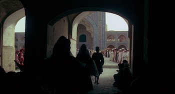 Movie still from “Arabian Nights” (1974), directed by Pier Paolo Pasolini – A group of people walking down a street; Extreme Wide shot, Low angle