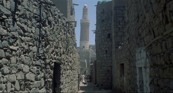 Movie still from “Arabian Nights” (1974), directed by Pier Paolo Pasolini – People walking down a street in an old city; Extreme Wide shot, Low angle
