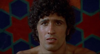 Movie still from “Arabian Nights” (1974), directed by Pier Paolo Pasolini – A person with curly black hair; Close Up shot, Low angle
