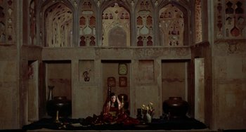 Movie still from “Arabian Nights” (1974), directed by Pier Paolo Pasolini – A woman sitting on the ground in a room; Extreme Wide shot, High angle