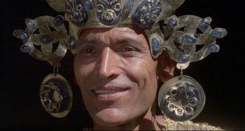 Movie still from “Arabian Nights” (1974), directed by Pier Paolo Pasolini – A man wearing a blue and gold headdress; Close Up shot, Low angle