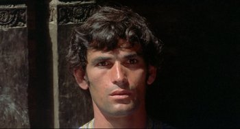 Movie still from “Arabian Nights” (1974), directed by Pier Paolo Pasolini – A person wearing a necklace; Close Up shot, High angle