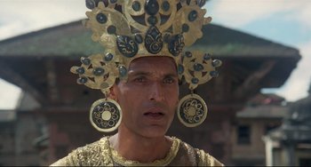 Movie still from “Arabian Nights” (1974), directed by Pier Paolo Pasolini – A man wearing a gold and blue headdress; Close Up shot, Low angle