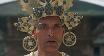 Movie still from “Arabian Nights” (1974), directed by Pier Paolo Pasolini – A person wearing a crown; Close Up shot, Low angle