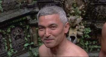 Movie still from “Arabian Nights” (1974), directed by Pier Paolo Pasolini – An older man with grey hair is smiling for the camera; Close Up shot, Low angle