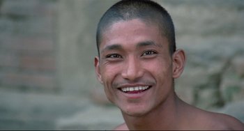 Movie still from “Arabian Nights” (1974), directed by Pier Paolo Pasolini – A person with a shaved head smiling; Close Up shot, Low angle