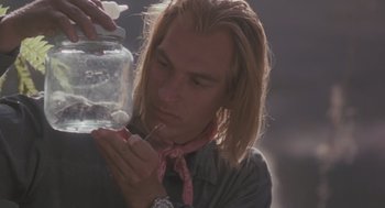 Movie still from “Arachnophobia” (1990), directed by Frank Marshall – A man with blonde hair is holding a jar of food; Close Up shot, Over the shoulder angle