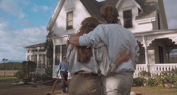 Movie still from “Arachnophobia” (1990), directed by Frank Marshall – Two people hugging in front of a house; Wide shot, Low angle