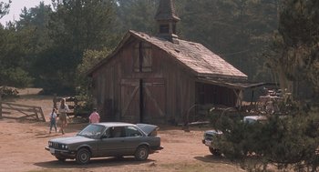 Movie still from “Arachnophobia” (1990), directed by Frank Marshall – An old wooden barn with an old car parked in front of it; Extreme Wide shot, High angle