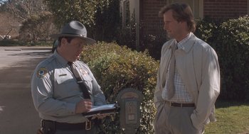 Movie still from “Arachnophobia” (1990), directed by Frank Marshall – Two men standing next to each other in front of a parking meter; Medium shot, Over the shoulder angle