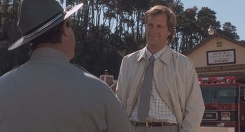 Movie still from “Arachnophobia” (1990), directed by Frank Marshall – A man in a suit and tie standing next to another man; Medium shot, Over the shoulder angle