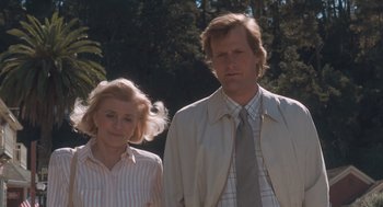 Movie still from “Arachnophobia” (1990), directed by Frank Marshall – An older woman standing next to a younger man in front of trees; Medium shot, Low angle