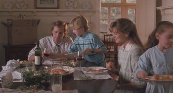 Three people sitting at a table with plates of food