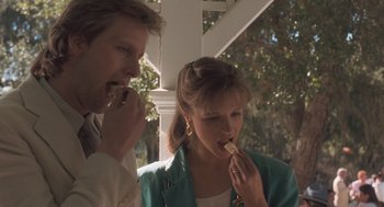 Movie still from “Arachnophobia” (1990), directed by Frank Marshall – A man and a woman are eating some food together; Close Up shot, Low angle