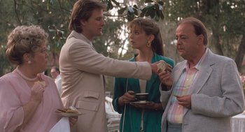 Movie still from “Arachnophobia” (1990), directed by Frank Marshall – A group of people standing next to each other on a street; Medium shot, Over the shoulder angle