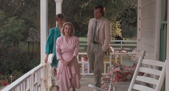 Movie still from “Arachnophobia” (1990), directed by Frank Marshall – A man and a woman standing on a porch with another man; Medium shot, Low angle