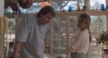 Movie still from “Arachnophobia” (1990), directed by Frank Marshall – A man and a woman standing next to each other in front of a window; Medium shot, Low angle