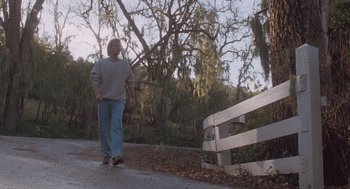 Movie still from “Arachnophobia” (1990), directed by Frank Marshall – An older man walking down the street near a fence; Wide shot, Low angle