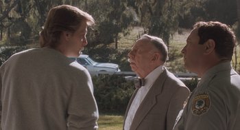 Movie still from “Arachnophobia” (1990), directed by Frank Marshall – Two men and a woman talking to each other outside; Medium shot, Over the shoulder angle