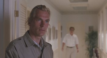 Movie still from “Arachnophobia” (1990), directed by Frank Marshall – A man standing in a hallway with another man standing in the background; Close Up shot, Over the shoulder angle