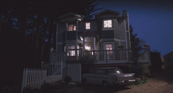 Movie still from “Arachnophobia” (1990), directed by Frank Marshall – A car parked in front of a house at night; Extreme Wide shot, Low angle