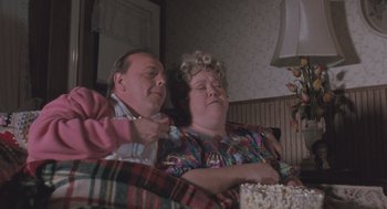 Movie still from “Arachnophobia” (1990), directed by Frank Marshall – A man and a woman sitting next to each other on a couch; Medium shot, High angle