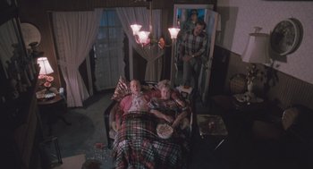 Movie still from “Arachnophobia” (1990), directed by Frank Marshall – A man and a woman in a bed in a living room; Wide shot, High angle