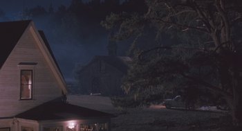 Movie still from “Arachnophobia” (1990), directed by Frank Marshall – A dark night with a car parked in front of a barn; Extreme Wide shot, High angle