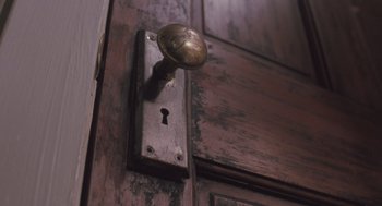 Movie still from “Arachnophobia” (1990), directed by Frank Marshall – An old door knob with a key hole on it; Extreme Close Up shot, High angle